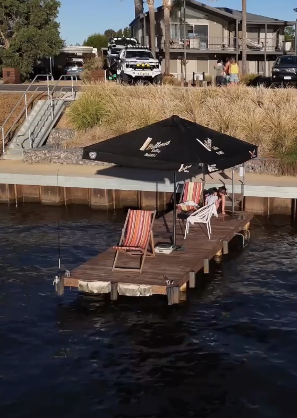 Private jetty by the water with umbrella and chairs